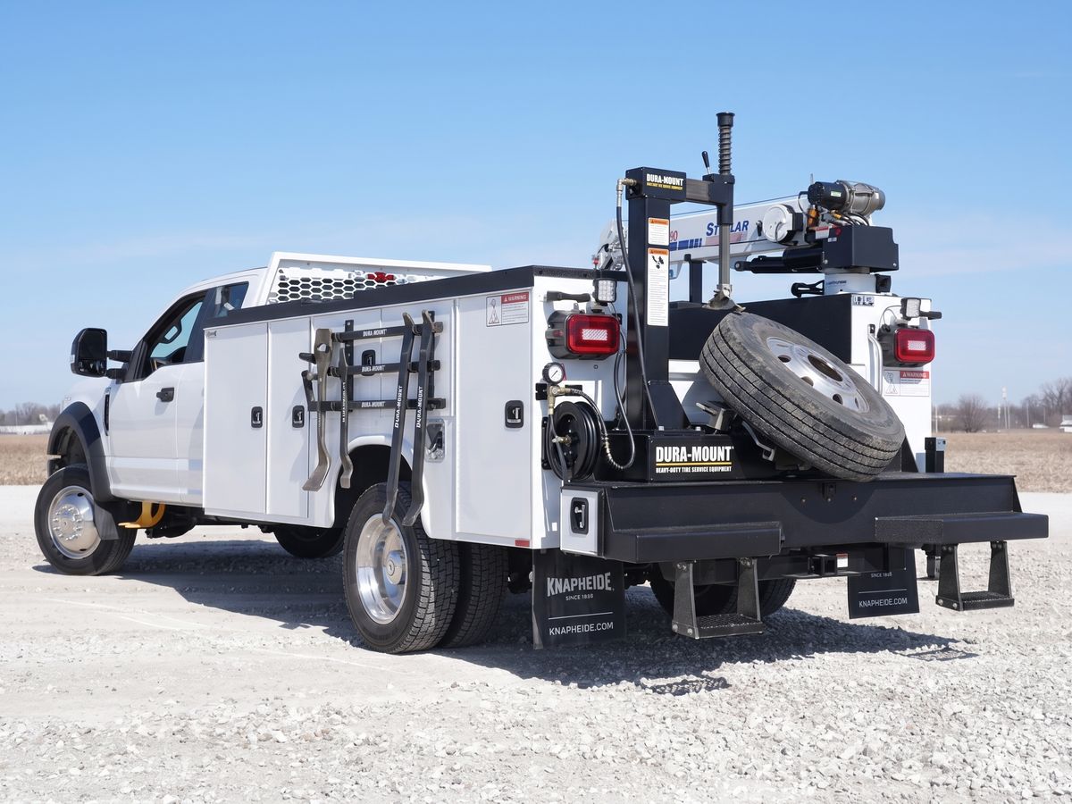 Mobile diesel service truck with a crane, tire equipment, and tool compartments